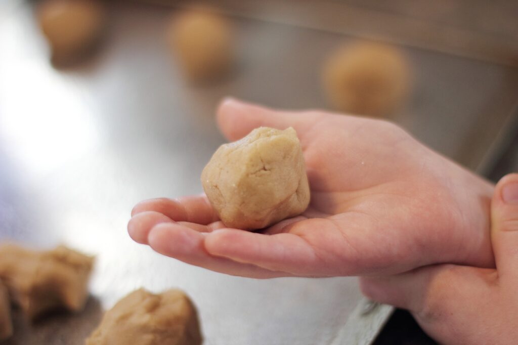 enfant avec pâte à cookies dans les mains -pâtisserie